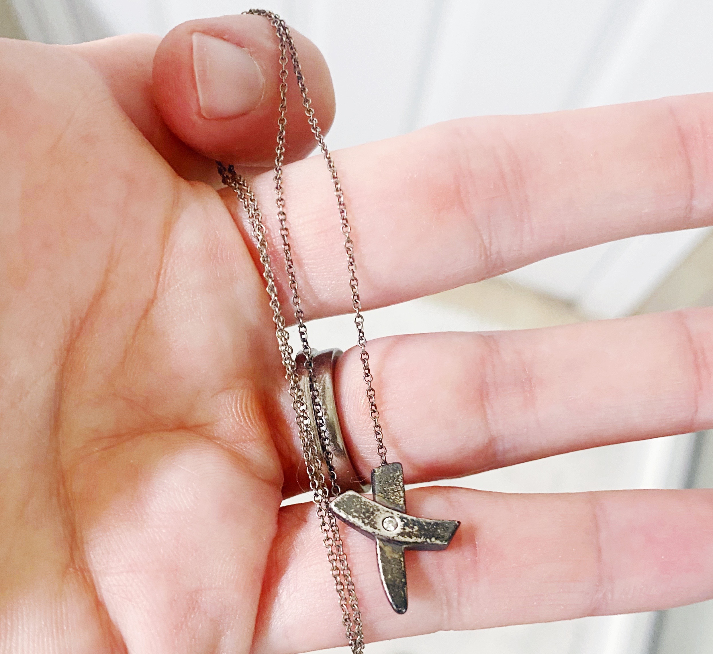 hand holding tarnished silver necklace