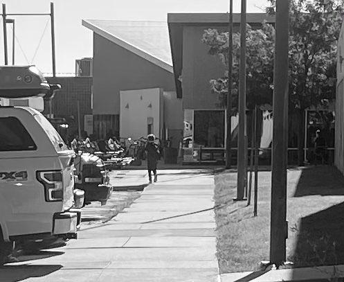 boy walking toward school along sidewalk